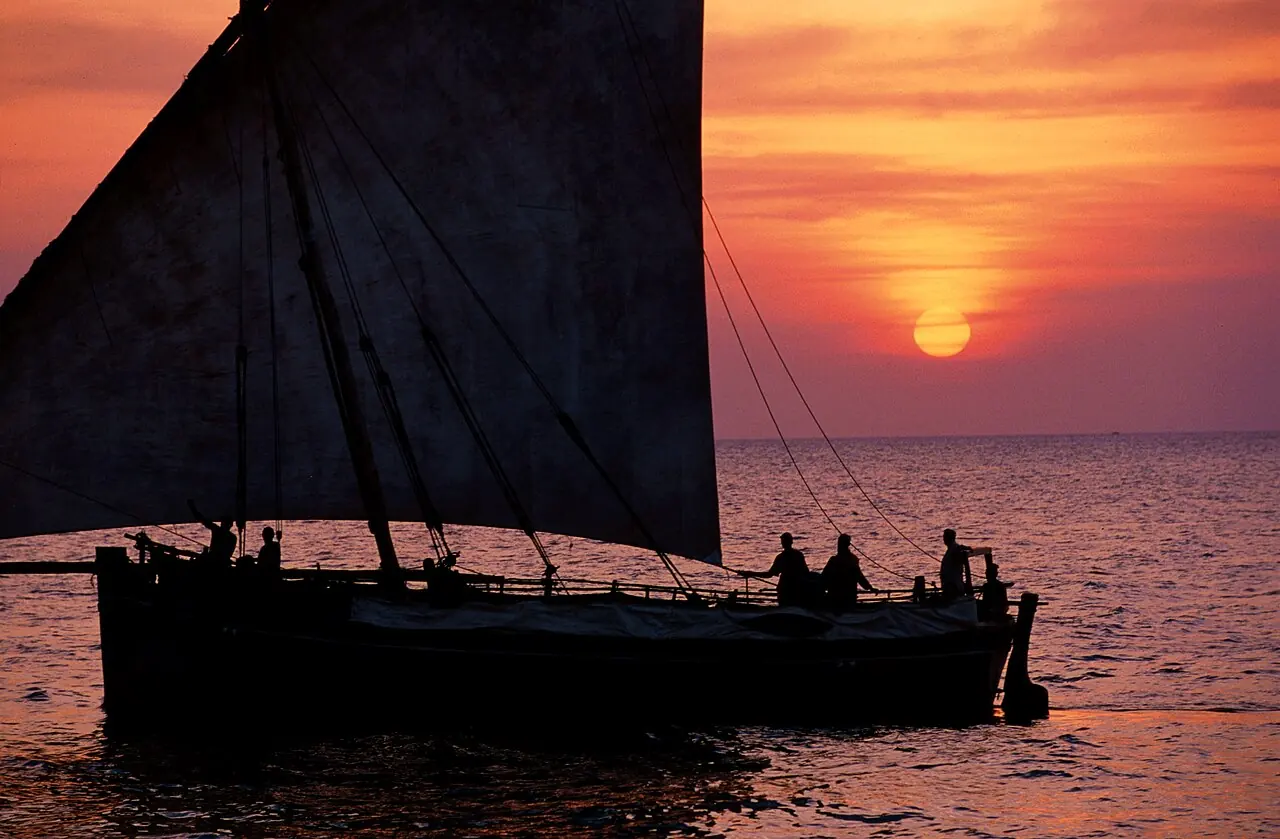 Silueta de un dhow contra el sol poniéndose en el océano Índico